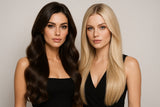 Zwei elegante Frauen mit langem, glänzendem Haar – eine Brünette mit voluminösen Wellen und eine Blondine mit glatter Struktur – posieren stilvoll nebeneinander vor neutralem Hintergrund; luxuriöses Markenbild für Hairdreams Extensions im High-End-Bereich.